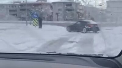 Bursa'da etkili olan kar yağışını fırsat bilen sürücü, otomobiliyle kavşakta